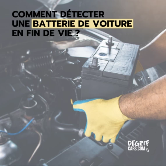 Mécanicien dans un garage en train de tester la batterie d’une voiture d’occasion, symbole d’un contrôle préventif avant panne.